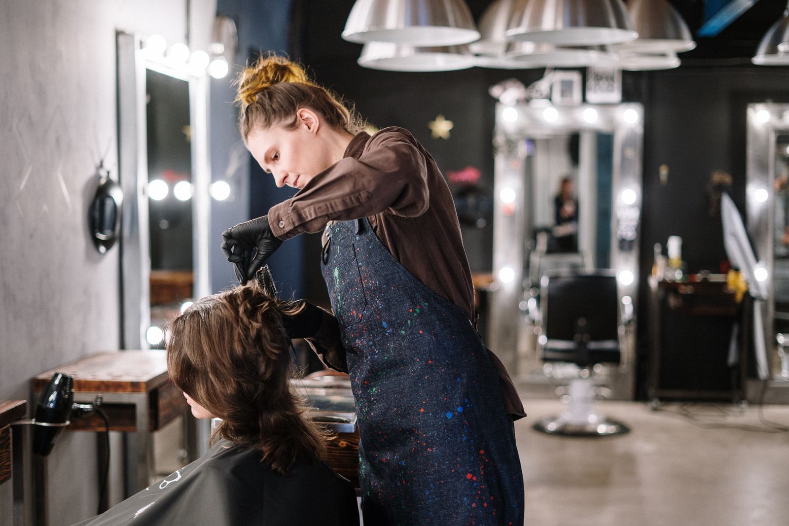 Salon stylist applying hair colour to a client — the kind of service moment that fuels salon Instagram marketing